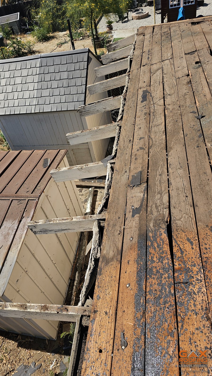 Weathered roof deck boards exposed during a tear-off in Westminster, California, the kind of condition nobody can see until the old roof comes off