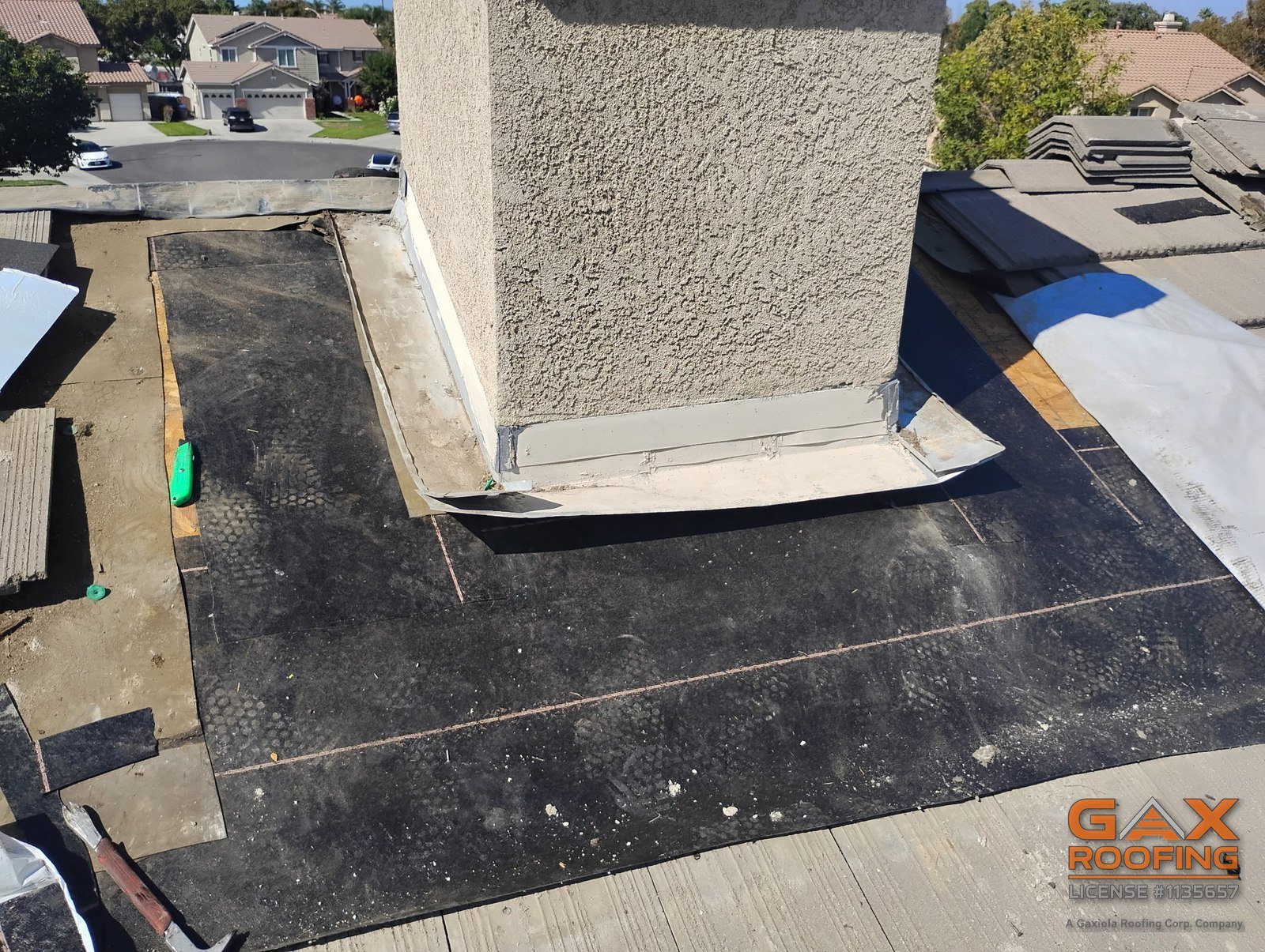 New base flashing installed around a chimney on a tile roof in Arcadia by GAX Roofing