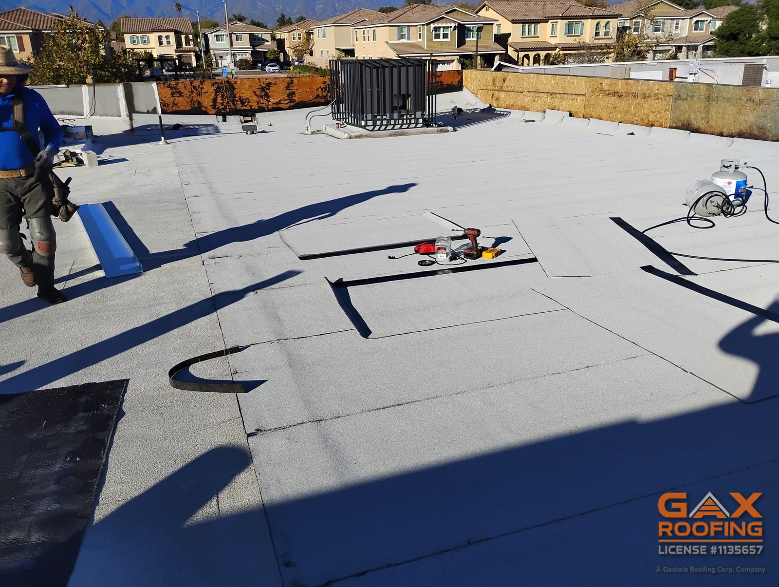 Sistema de techo plano blanco nuevo en un edificio comercial de Redlands con la cuadrilla de GAX Roofing terminando el campo