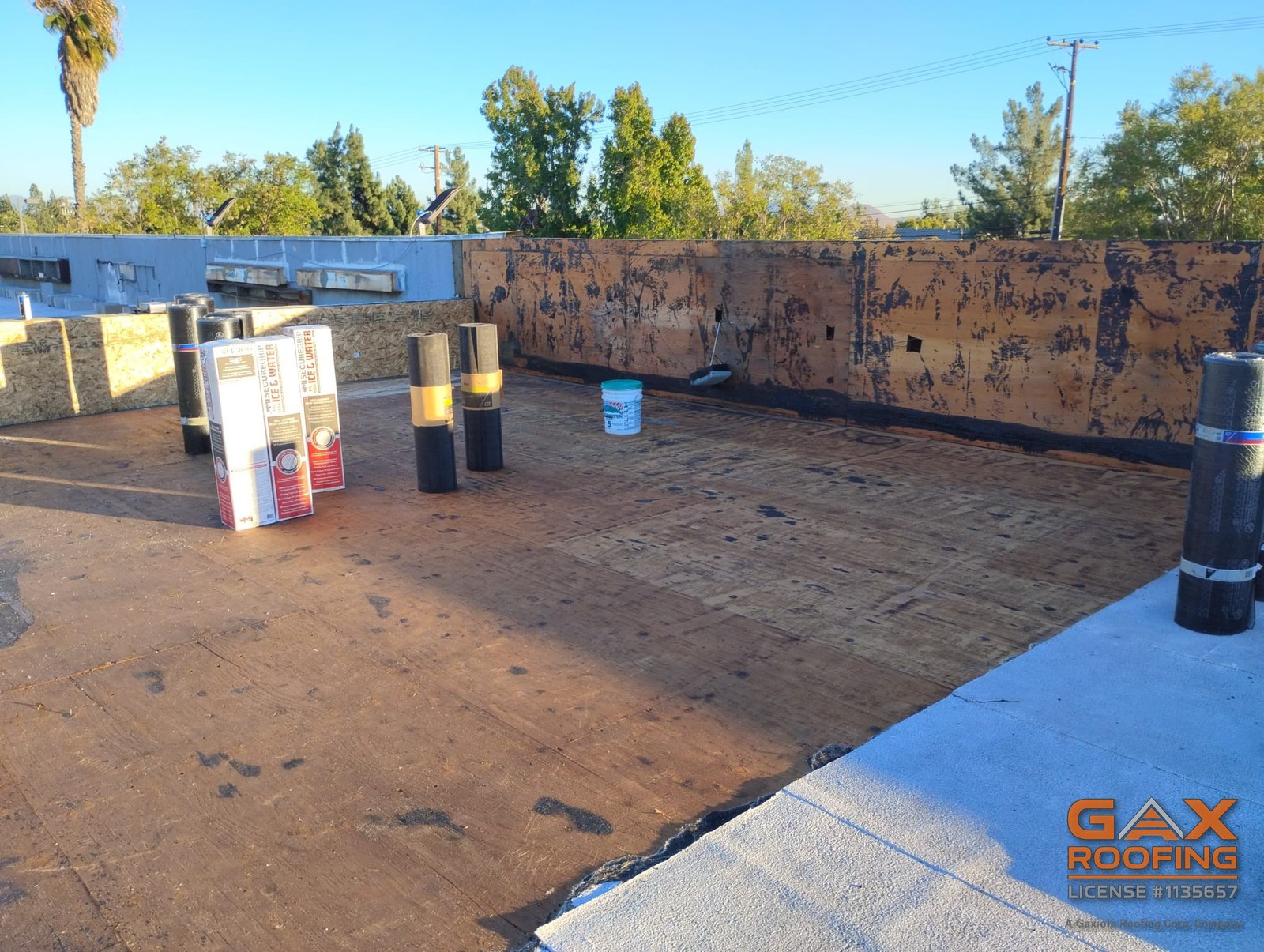 Cubierta del techo plano de un edificio comercial en Redlands expuesta despu&eacute;s del tear-off, con la madera podrida visible antes de la reparaci&oacute;n
