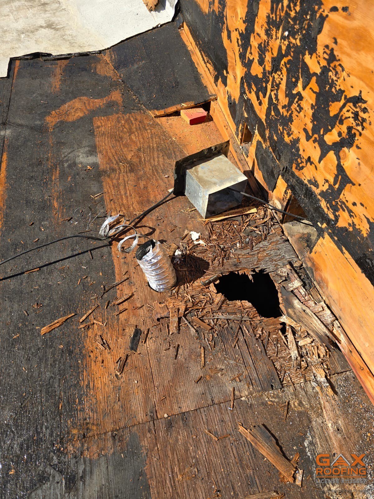 Rotted commercial roof decking opened through during a Redlands tear-off
