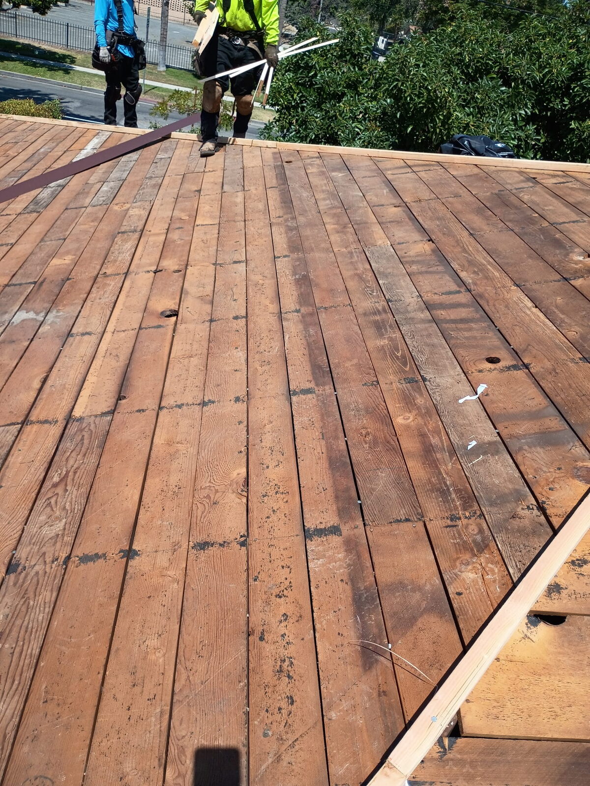 Entablado de madera nuevo instalado durante una remoción de GAX Roofing