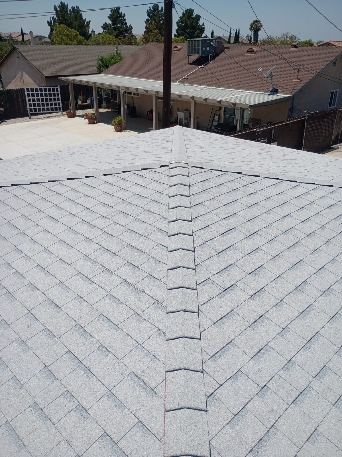 Cambio de techo terminado por GAX Roofing con tejas nuevas claras tipo cool roof