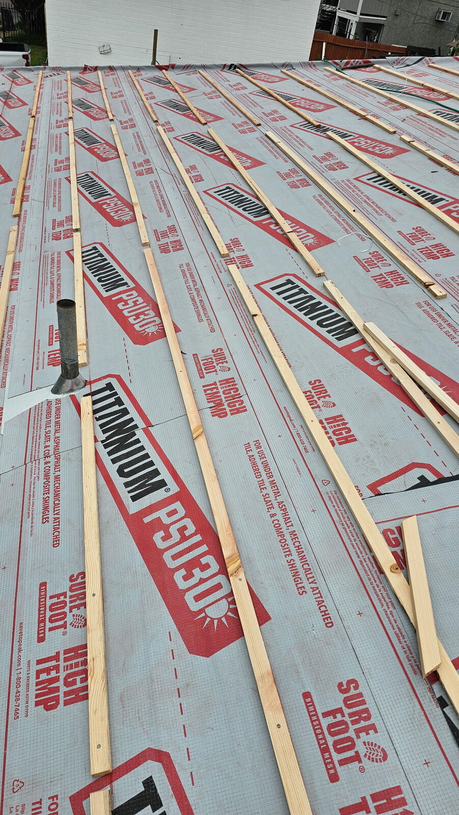 Bajo-tejas sintético instalado sobre un entablado limpio por GAX Roofing