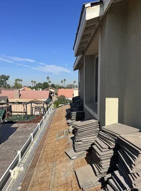 Tiles stacked and staged on roof deck during a lift and relay, ready for reinstallation