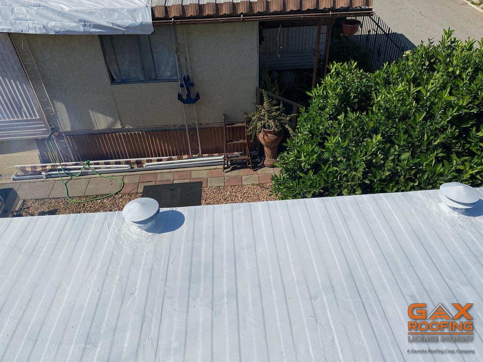 White silicone coating applied over the metal roof of a mobile home in Ontario by GAX Roofing, seams and vents sealed