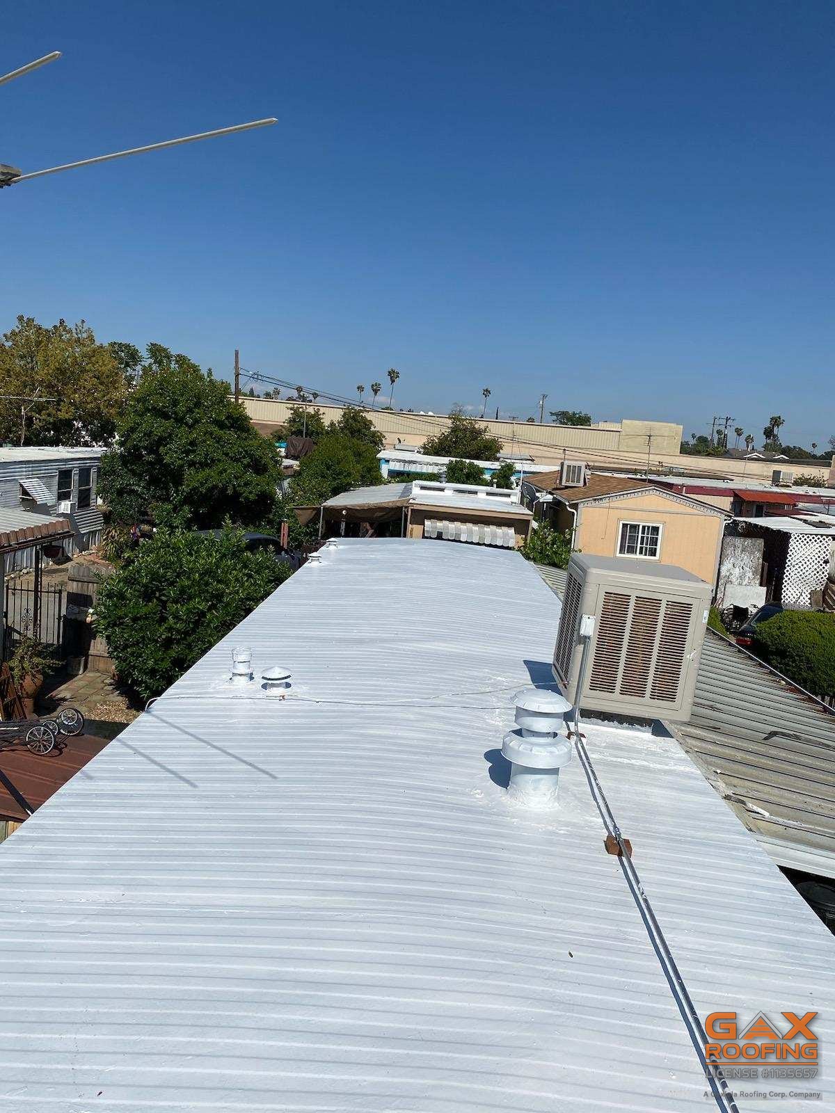 Coated mobile home roof in Ontario with vents sealed under the silicone