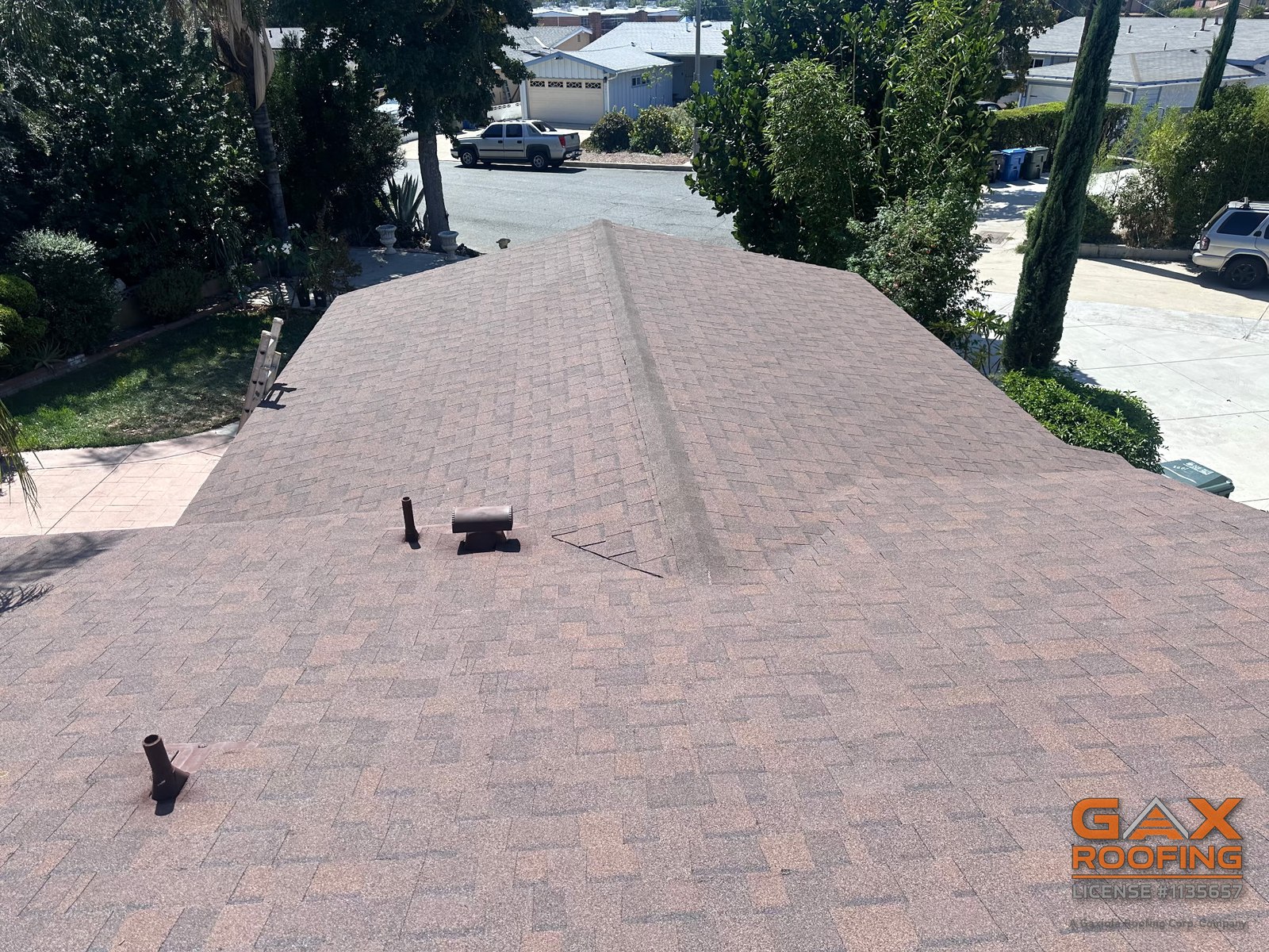 Techo de shingle arquitect&oacute;nico caf&eacute; terminado en West Covina, CA por GAX Roofing, con ventila a lo largo de la cumbrera principal y ventilas pintadas al tono