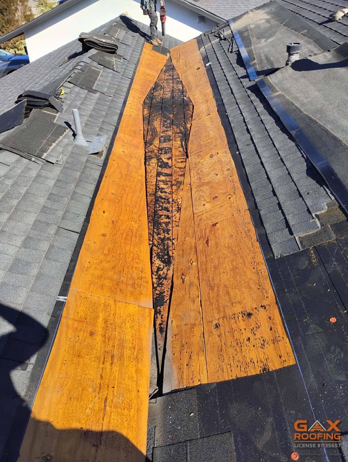Roof valley opened to bare decking in San Dimas, CA showing water damage down the channel