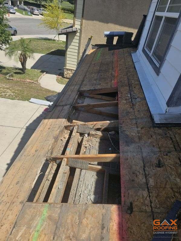 Rotted roof decking cut out at the eave in San Bernardino, CA exposing the rafters