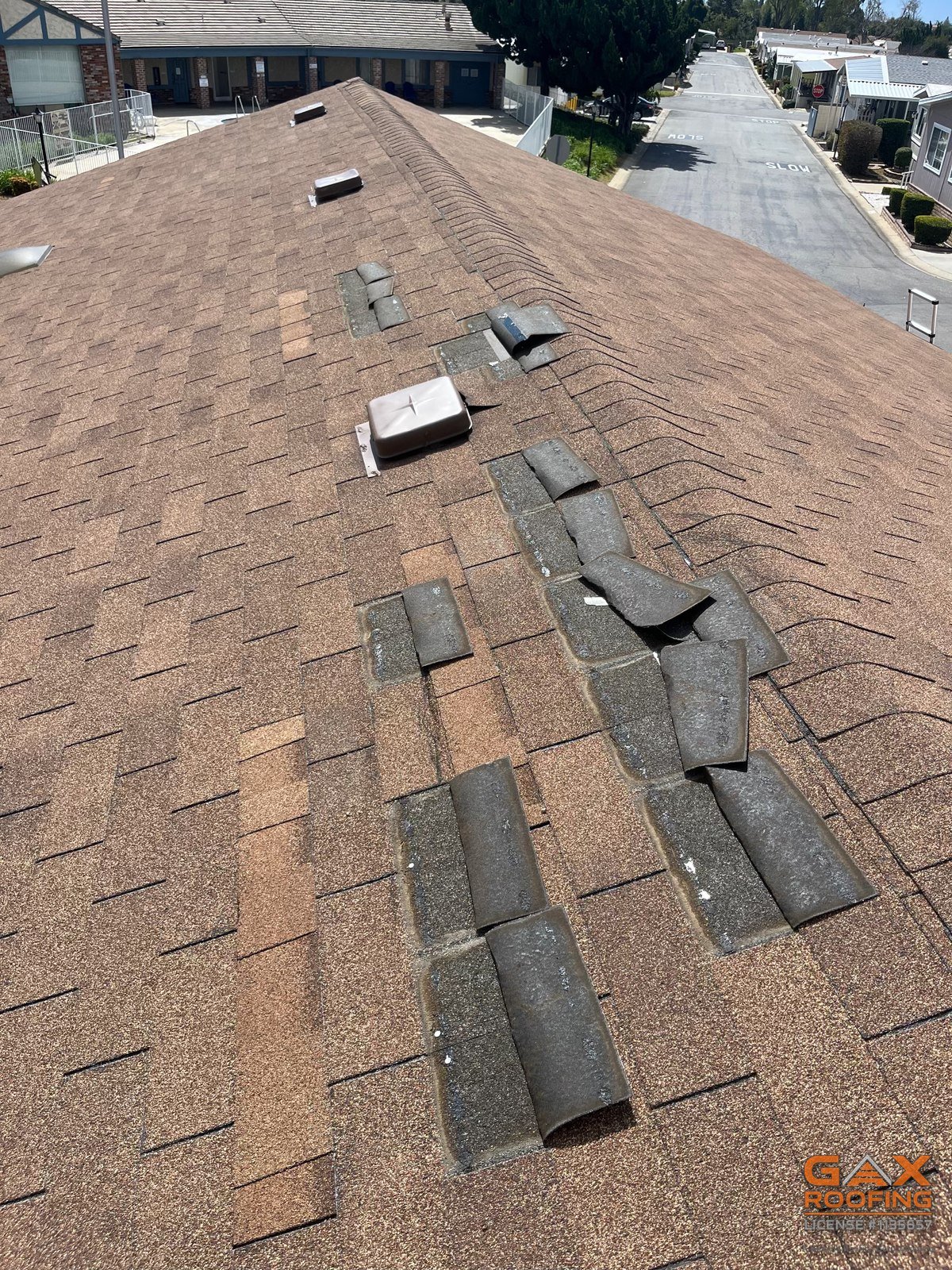 Three tab shingles blown loose and lying upside down on a roof during a GAX Roofing inspection