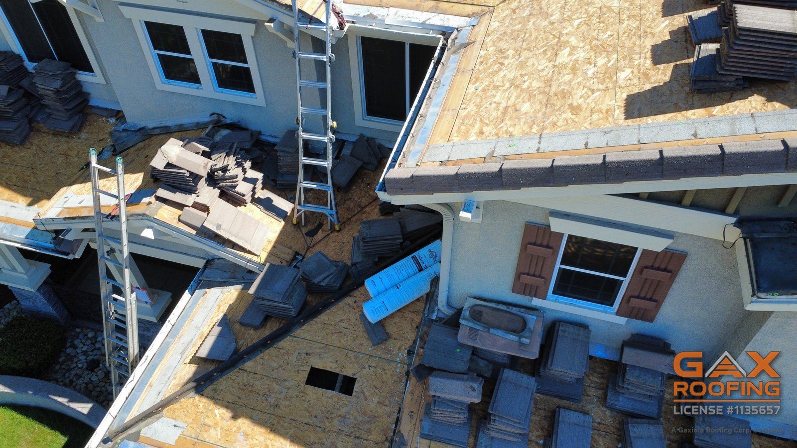 Rollos de membrana Westlake Royal TileSeal HT junto a teja de concreto apilada en un techo bajo en Rancho Cucamonga