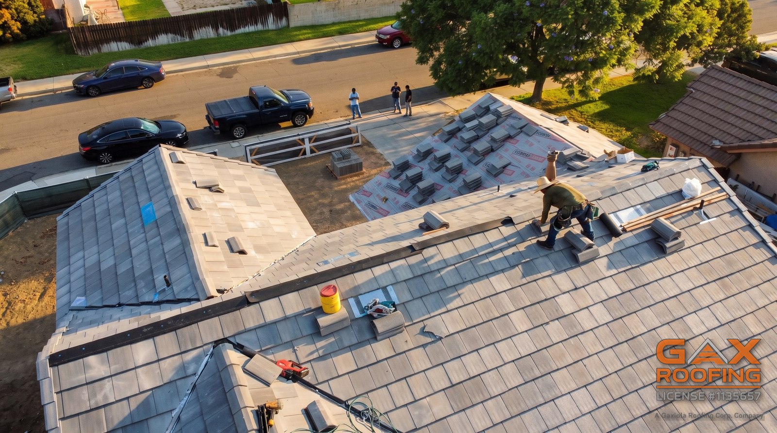 GAX Roofing crew working a tile replacement at golden hour