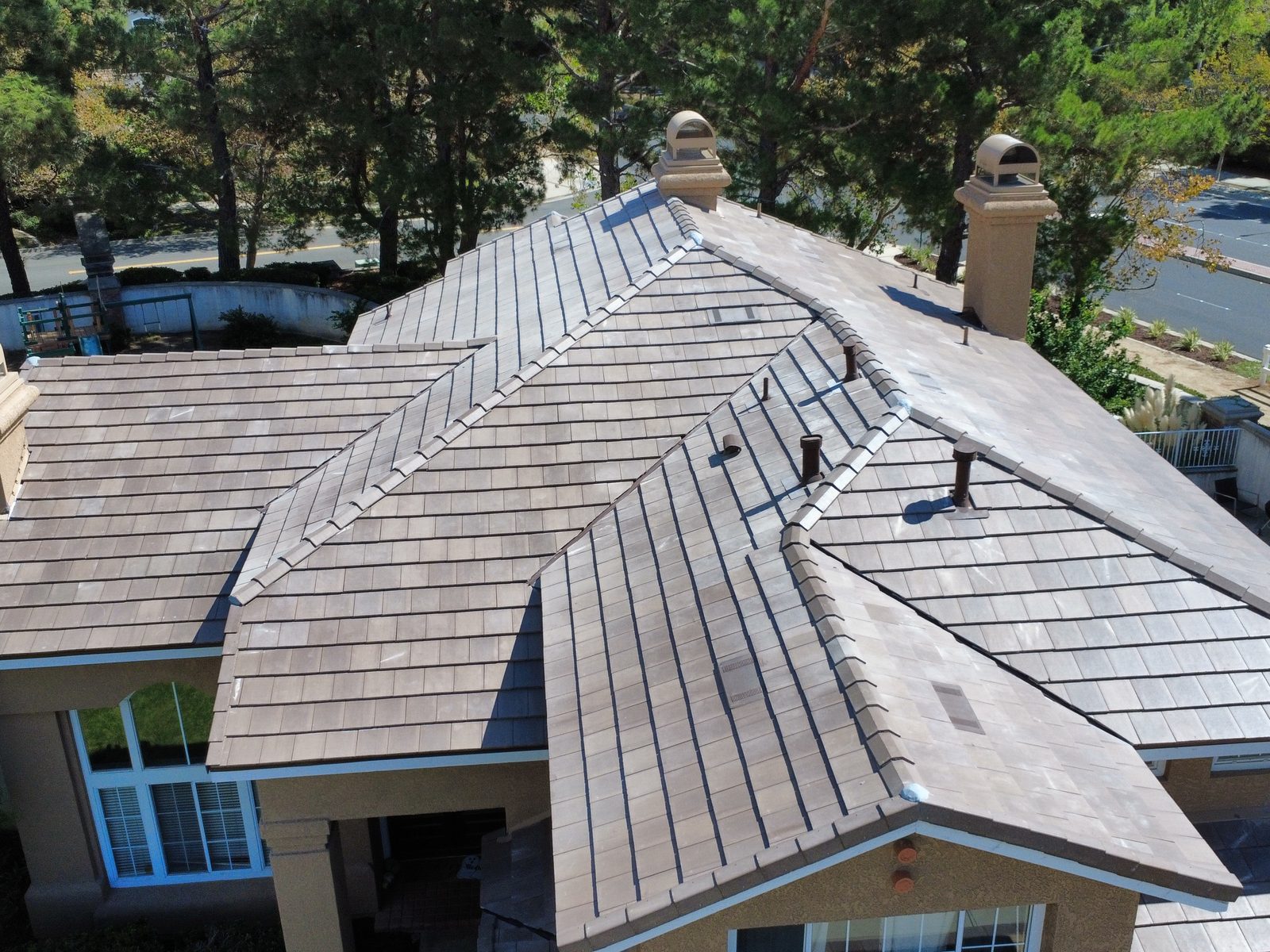 Techo terminado de teja nueva de concreto en una casa de Etiwanda, Rancho Cucamonga, vista de dron de las limatesas, cumbreras y chimeneas despu&eacute;s de un reemplazo de teja de GAX Roofing