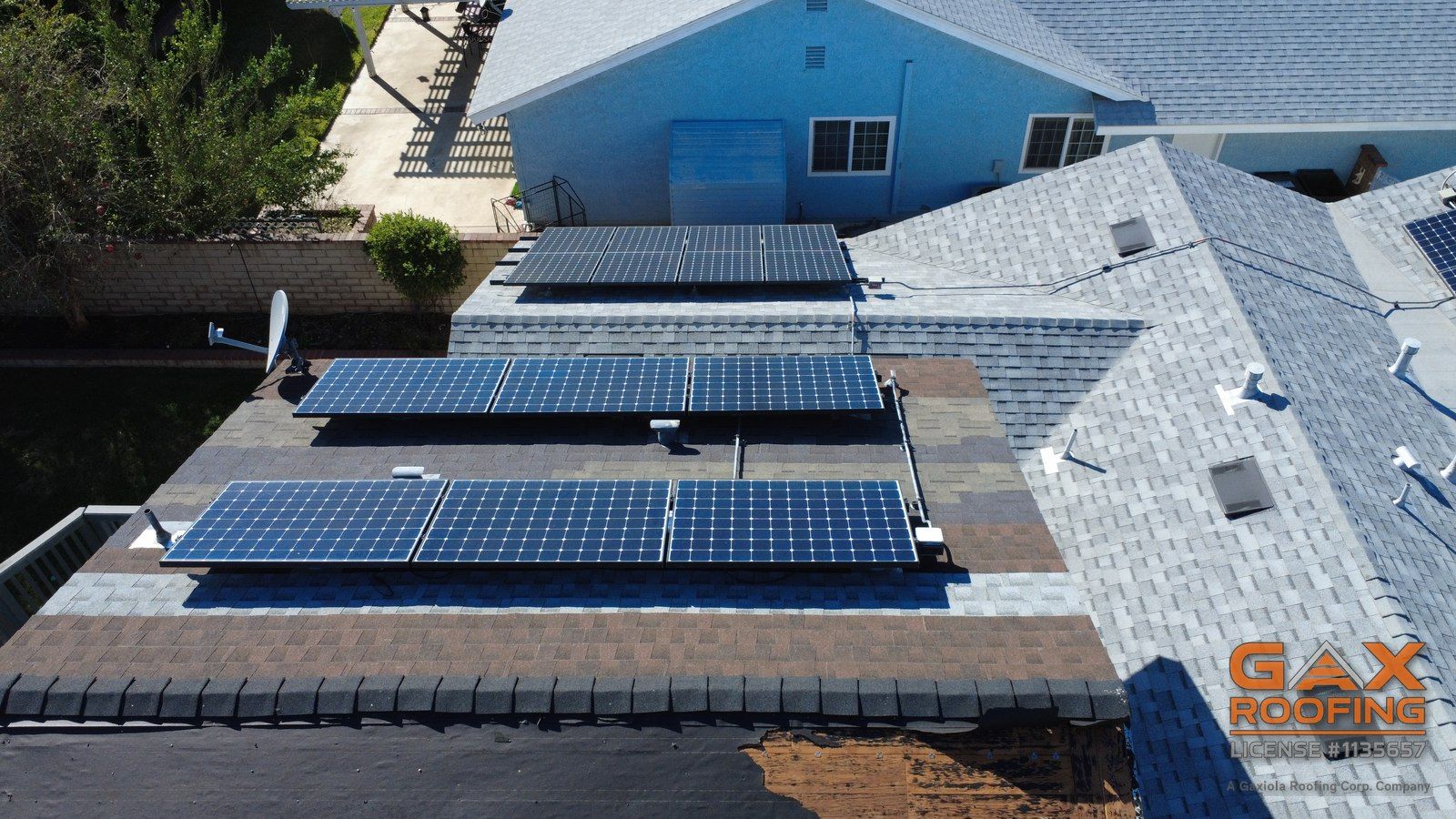 Solar arrays on shingle roof slopes with a damaged section beyond the ridge, seen from above in Rancho Cucamonga