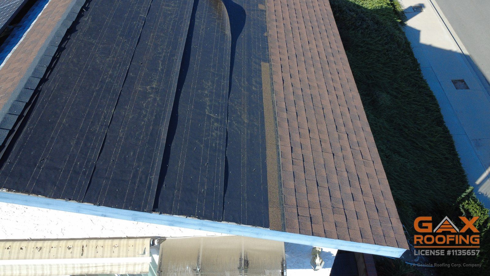 Shingle roof slope down to the eave after a wind blow-off, with old felt exposed and torn, Rancho Cucamonga