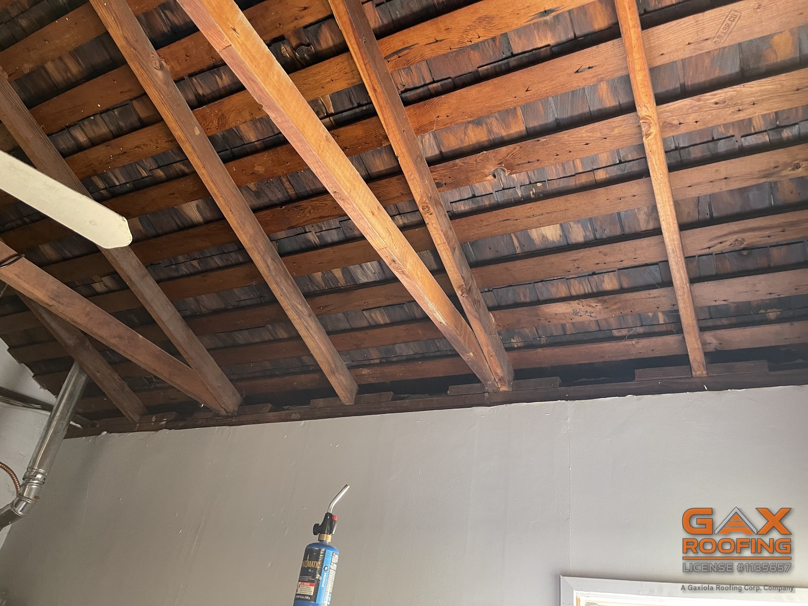 Stained wood shake visible between rafters inside a Loma Linda home